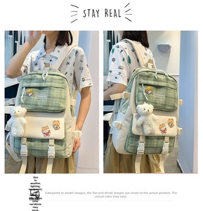 Detail of green plaid canvas backpack with cute bear patches and plush keychain accessory