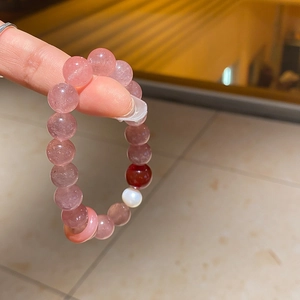 Detail of beaded bracelet with pink strawberry quartz and freshwater pearl on wrist
