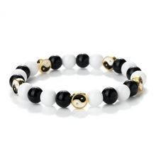 Detail of Yin Yang beaded bracelet with black and white natural stones and gold charms