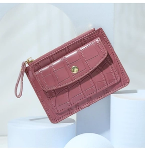 Close-up of mauve crocodile-embossed PU leather coin purse with zipper and metal buckle
