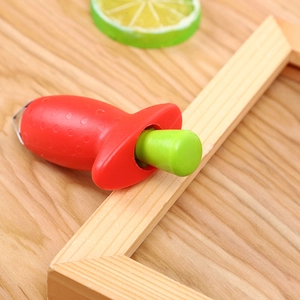 Macro view of stainless steel strawberry huller tool with red and green handle design
