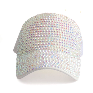 Macro detail showing iridescent rhinestones on a white fabric baseball cap surface