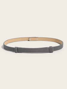 Close-up of a slim dark grey belt with cross-grain texture and silver buckle detail