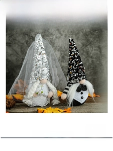 Groom and bride gnomes with sequins and bridal veil on a rustic wooden surface