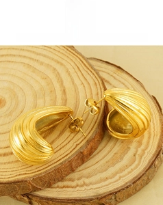 Macro view of 18K gold plated ribbed earrings with geometric hollow design on wood