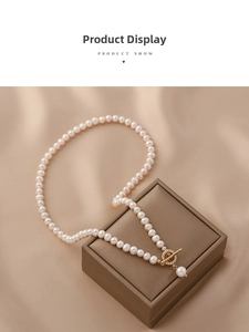Detailed close-up of natural freshwater pearl necklace with golden zircon OT clasp and silk decor