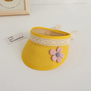 Detail of yellow woven sun hat with white lace trim and pink flower decoration
