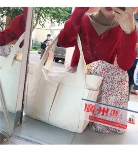 Détail d'un grand sac cabas en toile avec deux poches frontales et un tissu épais robuste