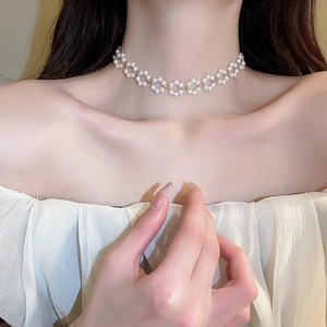 Gros plan sur un collier ras du cou élégant en perles blanches sur un mannequin