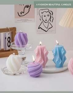 Artistic pastel geometric spiral scented candles displayed on a glass holder with decor