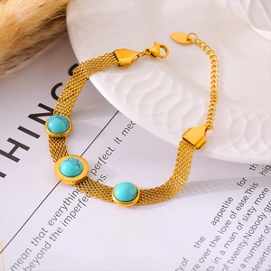 Vintage 18k gold plated mesh bracelet with turquoise beads on white ceramic plate