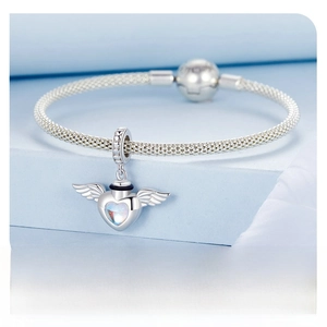 Detail of S925 sterling silver mesh bracelet with winged heart pendant and blue gemstone
