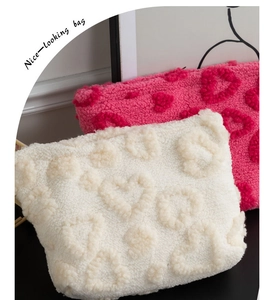 Κοντινή λεπτομέρεια από λευκά και ροζ βελούδινα τσαντάκια καλλυντικών με καρδιές