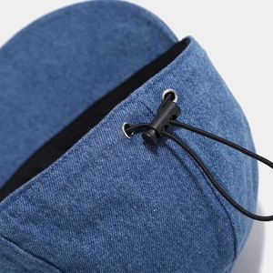 Detail of washed denim cap with adjustable elastic drawstring and plastic spring buckle