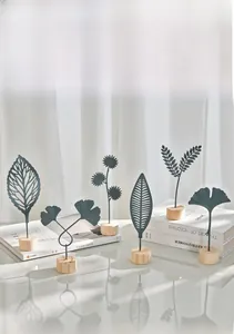 Detailed view of nordic metal ginkgo leaf ornaments with wooden base on books