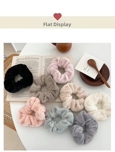 Detailed close-up of colorful soft faux rabbit fur scrunchies on a minimalist background