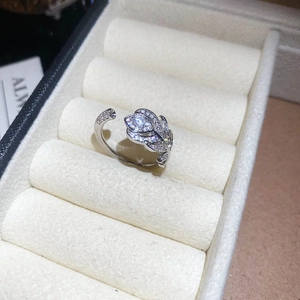 Dettaglio anello aperto in argento con design a piuma e brillanti pietre di zircone