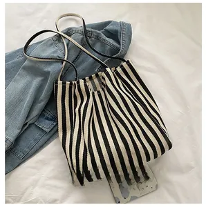 Detailed top view of striped canvas tote bag size comparison with a smartphone