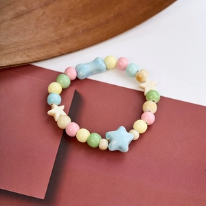 Detail of handmade ceramic bracelet with macaron beads and blue star charms