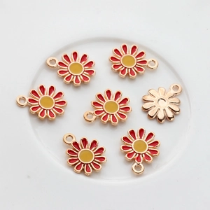 Macro detail of daisy alloy pendants with red and yellow oil drip finish for DIY crafts