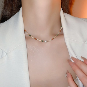 Collier en perles colorées avec perle irrégulière et détails dorés porté par un mannequin