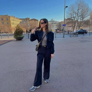 Giacca blu scuro a collo alto con grandi tasche e pantaloni a gamba larga a righe