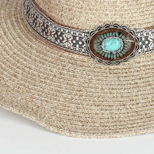 Dettaglio cappello di paglia con pietra turchese e finiture argentate in stile bohémien