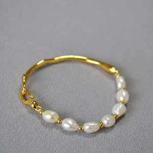Detailed close-up of baroque pearls and irregular gold-plated brass twig bracelet