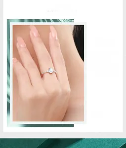Close-up of S925 silver ring featuring an oval moonstone with shimmering fire and cubic zirconia