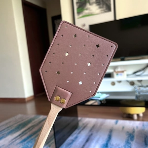 Fly swatter with pink leather head and long wooden handle for home pest control