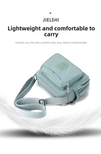Detailed view of light green nylon crossbody bag with adjustable strap and feathers