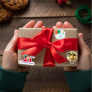 Creative Happy New Year decorative stickers on a gift box for festive party packaging
