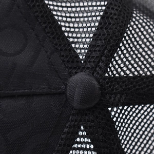 Detail view of the black mesh breathable panels and central button on a baseball cap