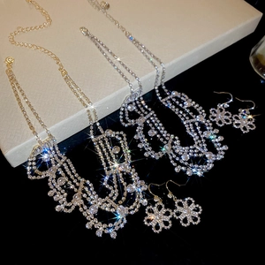 Close-up of gold and silver flower jewelry sets with tassels and crystals on black stands