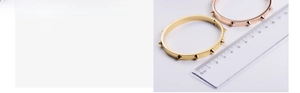 Detailed close-up of rivet bangle in gold and rose gold plating with ruler measurement