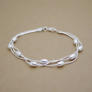 Detail of silver multi-layer snake chain bracelet with polished oval beads and lobster clasp