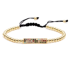 Adjustable black woven bracelet with gold beads and a multicolor zircon rainbow bar charm