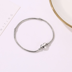 3mm silver snake chain bracelet with heart clasp on light pink minimalist background