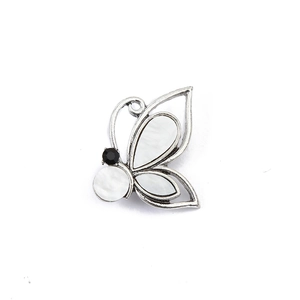 Detail of silver butterfly brooch featuring white mother-of-pearl and black rhinestones