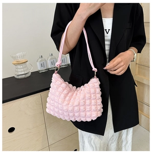 Detailed view of pink bubble textured shoulder bag worn by model in minimalist setting