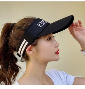 Detail of black sun visor hat featuring side stripes and KMQ embroidery on breathable fabric