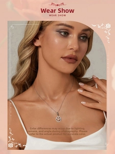 Close-up of a high-polish silver tree pendant necklace worn by a model on a pink backdrop
