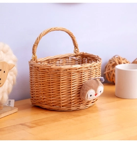 Detail of hand-woven wicker storage basket featuring a cute owl plush toy ornament