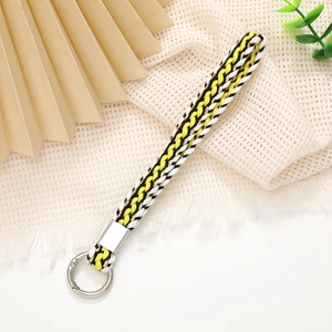 Detail of hand-woven wrist strap lanyard with yellow, black, and white cord pattern