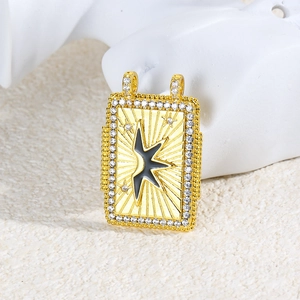 Macro shot of rectangular gold charm with black star pattern and zircon inlay