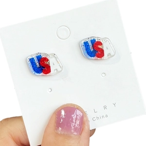 Detailed view of patriotic USA letters stud earrings with red white and blue glitter
