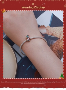 Detail of s925 silver bracelet with a colorful Christmas snowman enamel charm on wrist