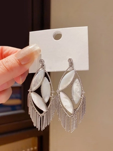 Detailed view of silver long fringe earrings with oval shell inlay and crystal studs