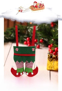 Detailed view of Christmas elf leg gift bag with red boots and white fuzzy pom-poms
