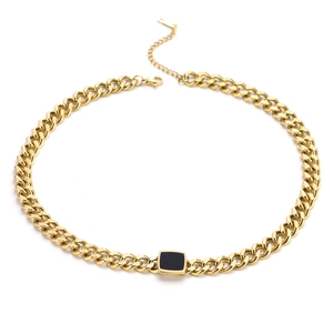 Detail of gold Cuban chain with black square pendant and lobster clasp for women